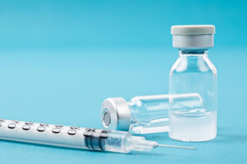 Two vials of research peptides with an insulin syringe drawn slightly with clear liquid inside, representing retatrutide and it's potential to ease ADHD food noise